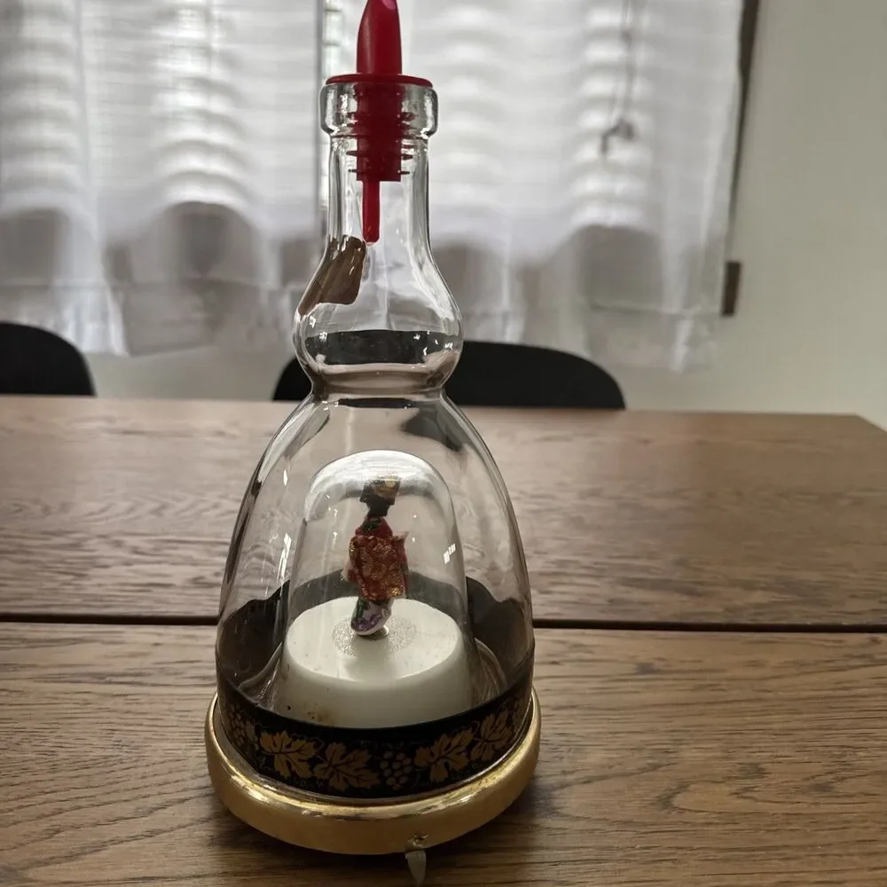 vintage Lucas Bols musical liqueur bottle featuring a  rotating geisha Inside